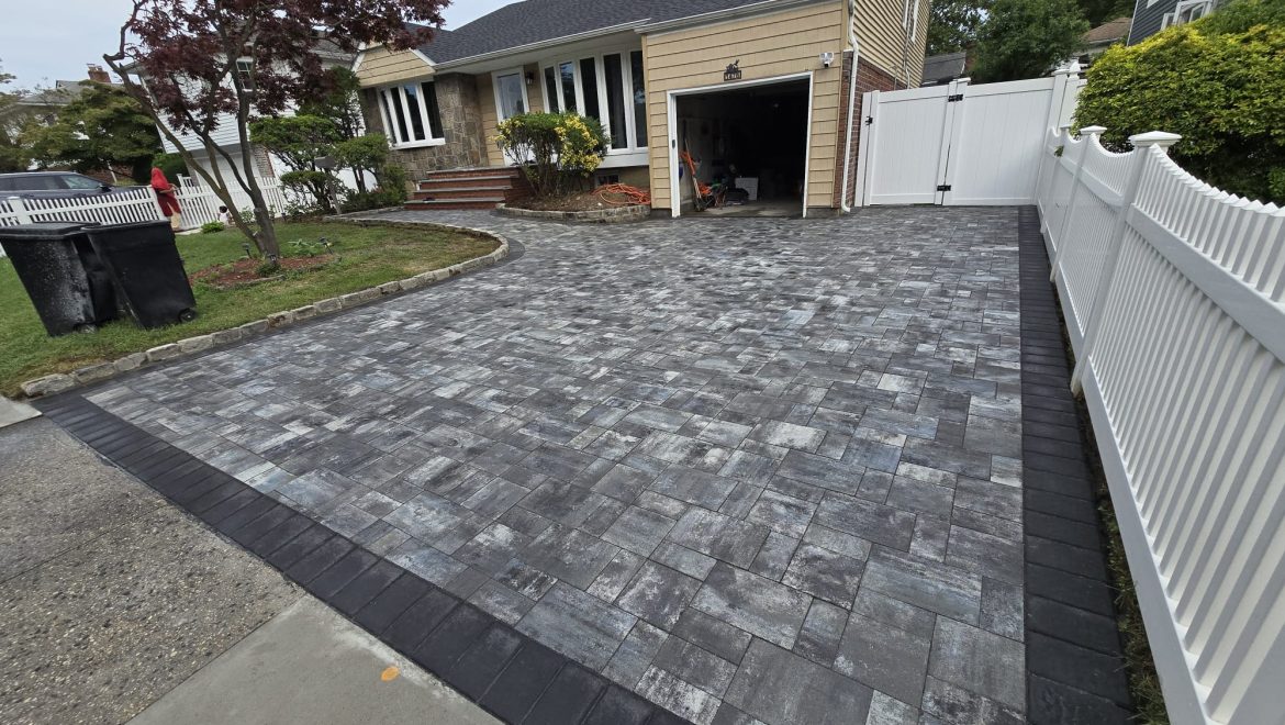 A contractor expertly lays asphalt, creating a smooth and stylish driveway.