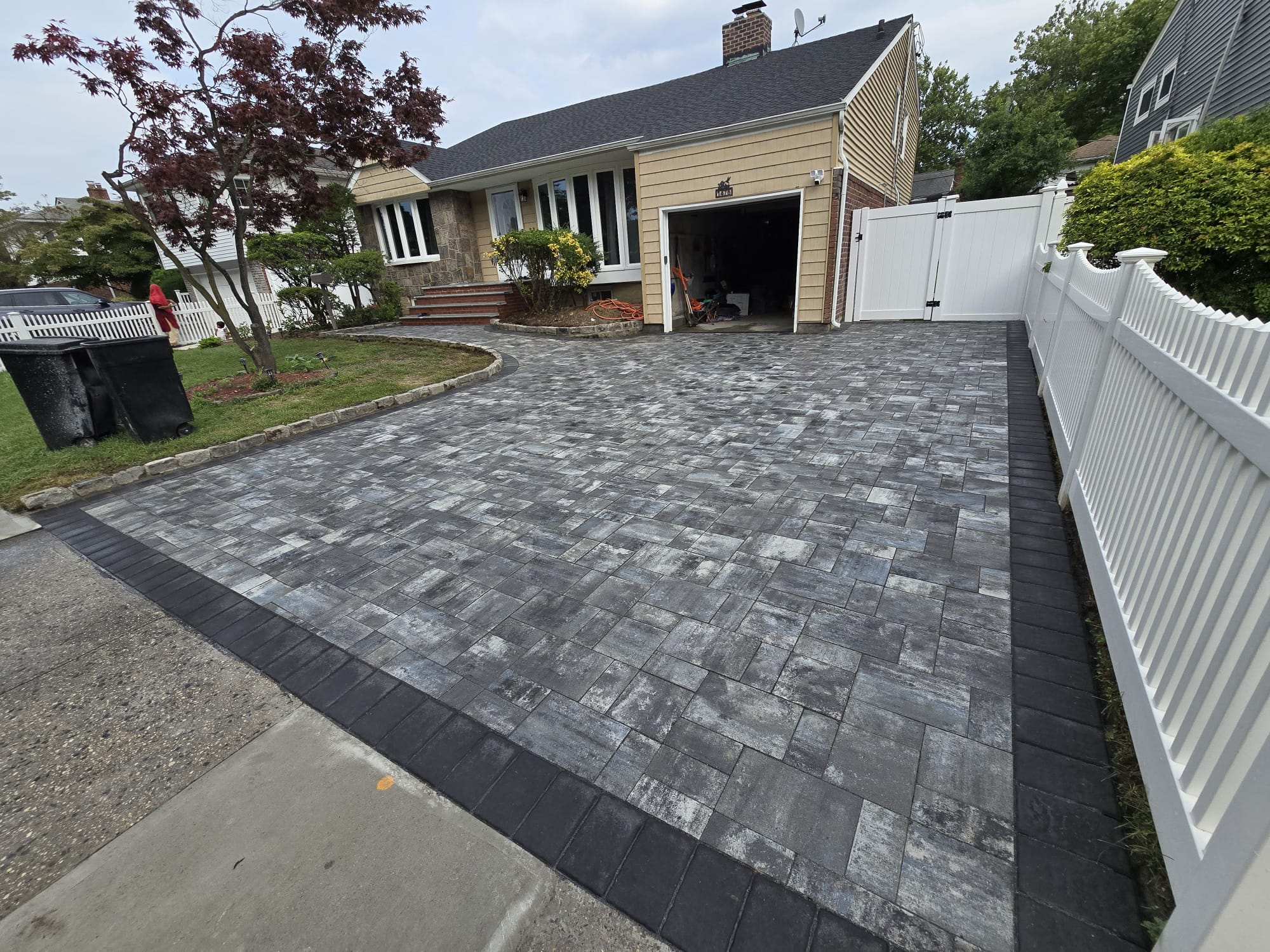 A contractor expertly lays asphalt, creating a smooth and stylish driveway.