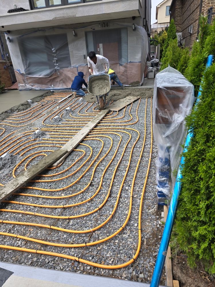 A heated driveway installation showing heating cables being laid beneath concrete, ensuring a snow-free surface for winter.