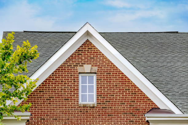 Close-up of a brick home's rooftop with clean, intact shingles representing effective roof maintenance.