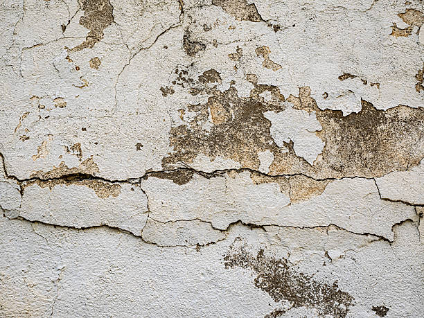 Cracked and weather-damaged stucco wall in NYC showing signs of staining, moisture intrusion, and surface decay.