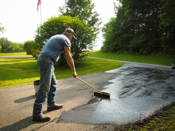 Applying protective sealant to concrete driveway surface
