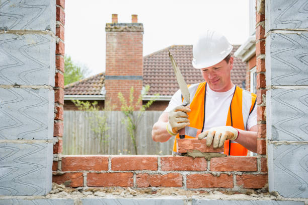 Brick mason restoring a window frame on a residential home, focused on detail and craftsmanship in a warm neighborhood setting.
