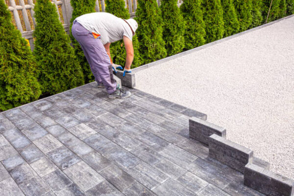 paver at work. a paver is laying paving stones. laying concrete paving stones.