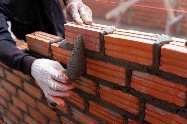 masonry services in NYC showing bricklaying with strong mortar for long-lasting walls