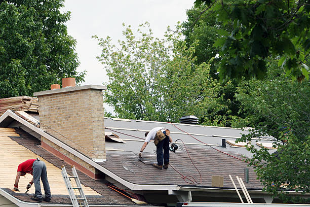 Shingle Roof Repair in progress with workers replacing old shingles and repairing roof decking.
