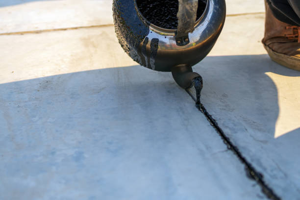 Worker sealing concrete cracks with Thoroseal waterproofing coating to protect against leaks and moisture