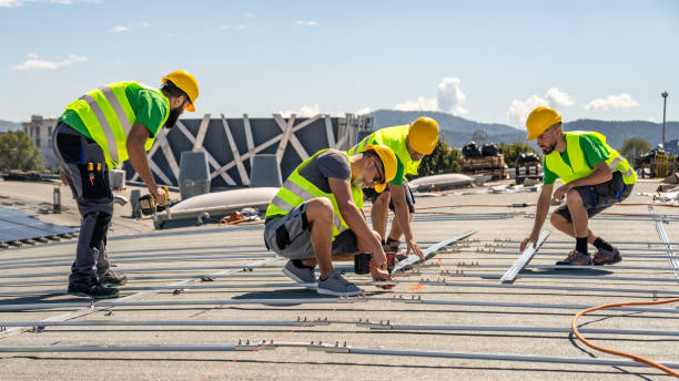 Workers installing TPO roofing system with fasteners on a new flat commercial roof for energy efficiency and durability.