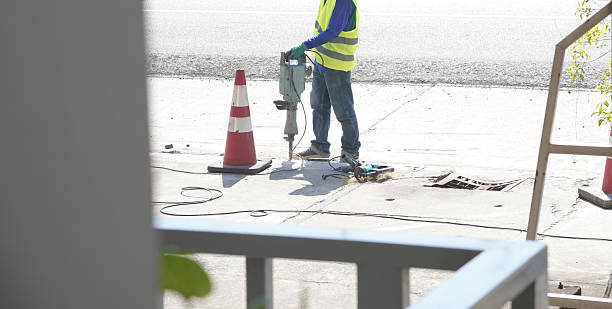 DOT violations sidewalk repair worker using jackhammer to fix damaged concrete in NYC