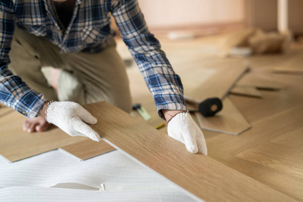 Worker installing flooring wood parquet in NYC home