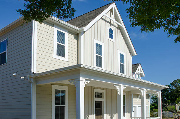 Modern two-story house exterior with beige insulated vinyl siding panels, offering energy efficiency and a stylish finish.