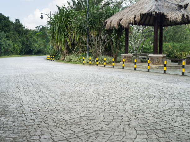 Outdoor stamped cement driveway with decorative stone pattern near a garden pavilion