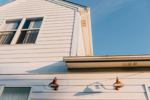 Close-up view of a house exterior with clean wood siding panels and windows, showcasing durable and stylish siding finish.