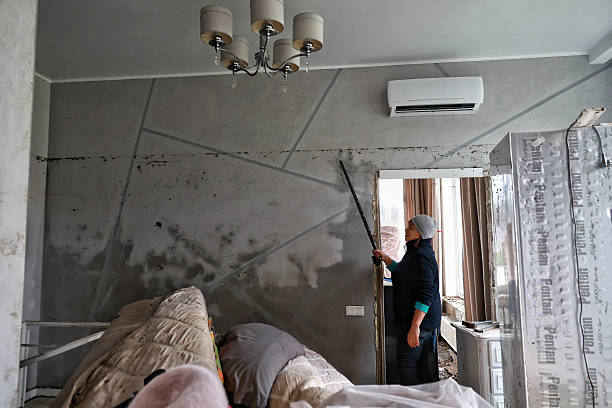 bedroom renovation in progress worker repairing and upgrading bedroom walls in NYC home.