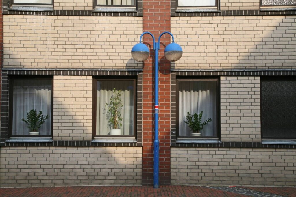 modern brick facade with windows and blue street lamp