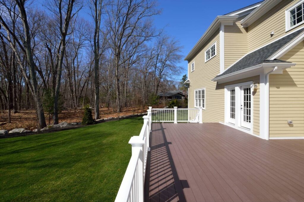Spacious backyard with a newly installed composite deck and white railings in New York City home