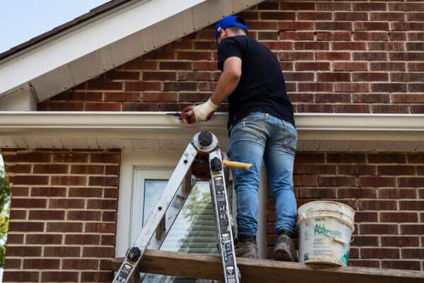Professional gutter repair and maintenance service on a residential property in NYC.